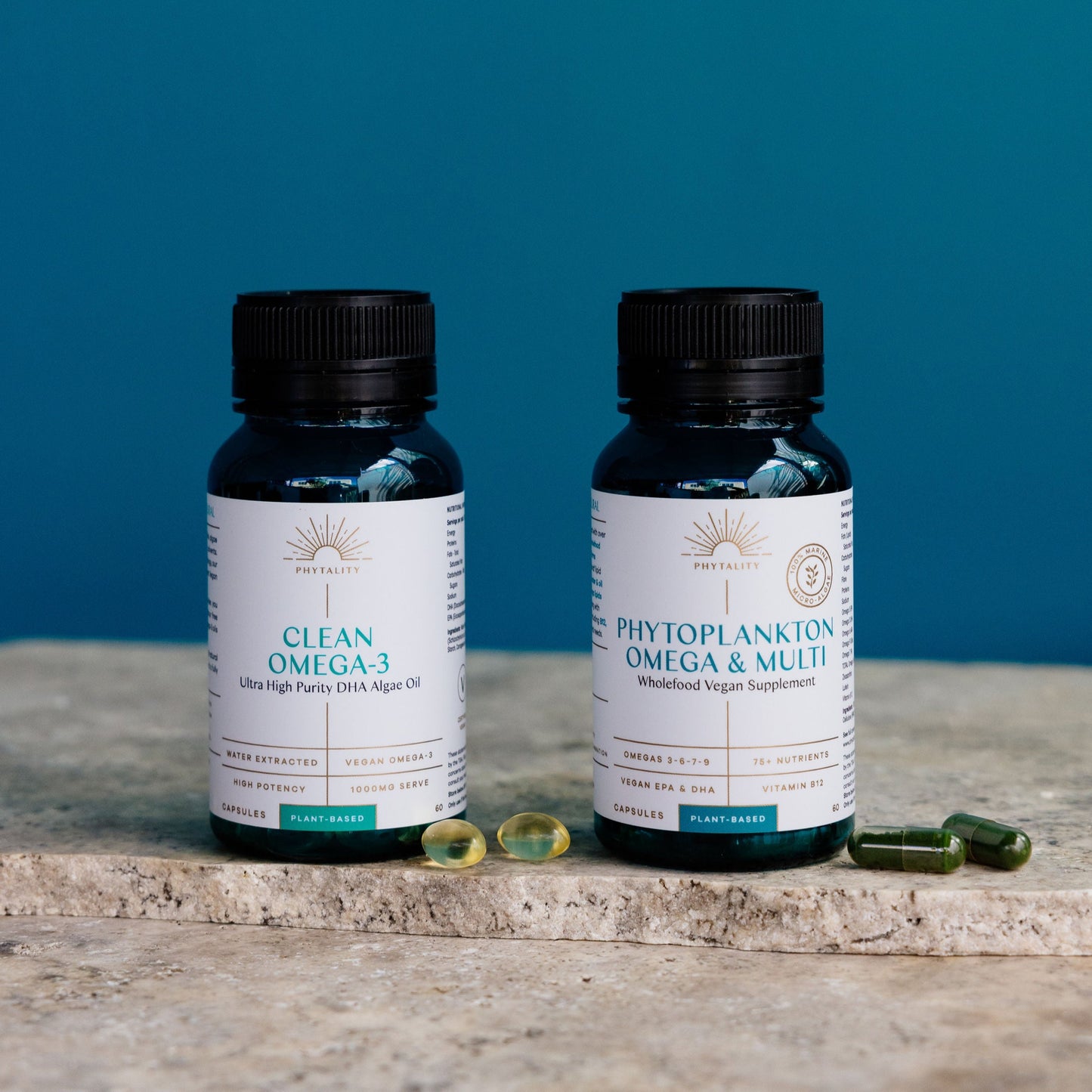 Two bottles of Phytality Capsuless on a stone surface with a blue background