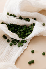 Fermented chlorella tablets scattered on white linen cloth